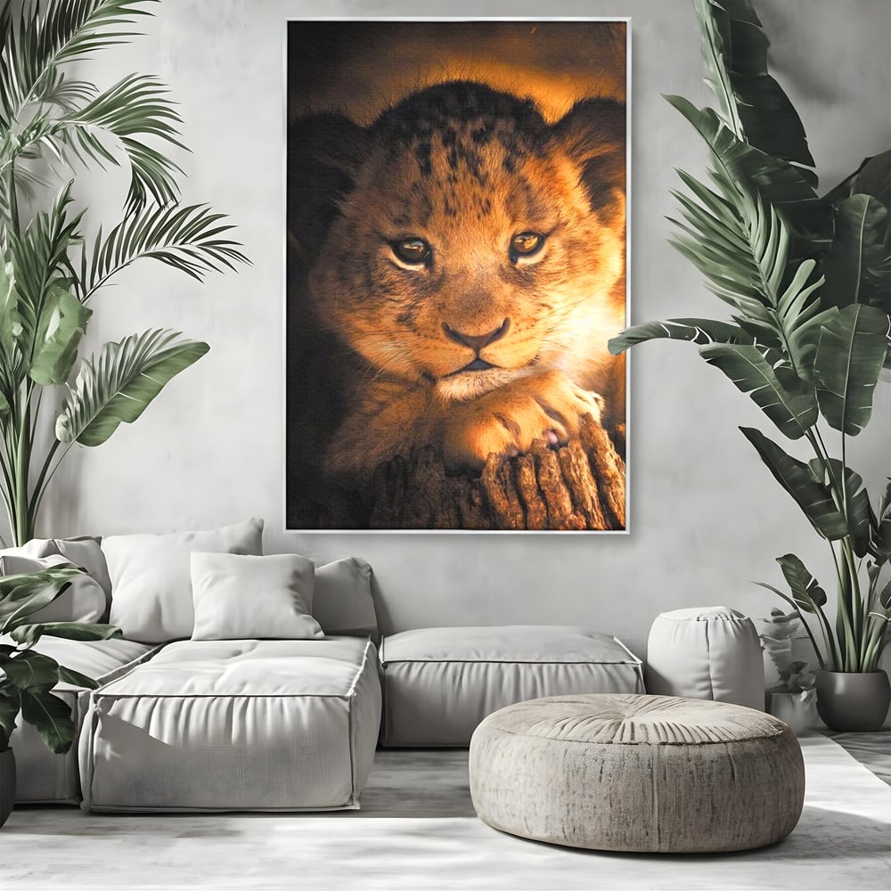 Tablou canvas cu tablou canvas cu portret de pui de leu, in rama de aluminiu argintiu, pe perete intr-un living